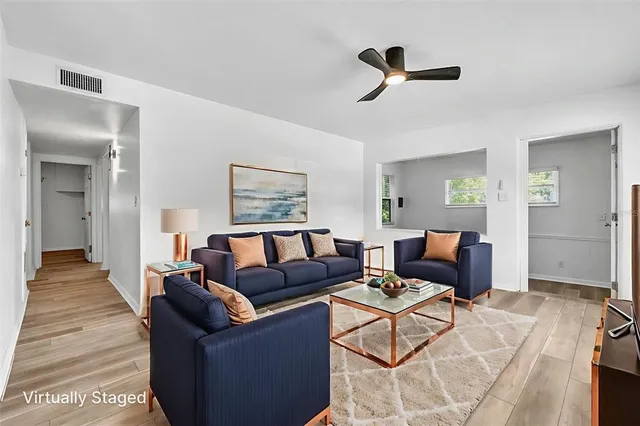 a living room with furniture and a wooden floor