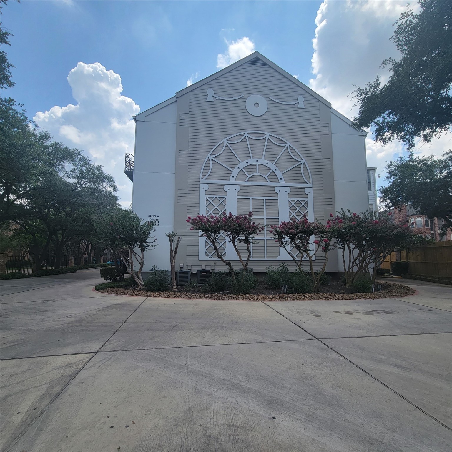 a large building with a large parking space and trees