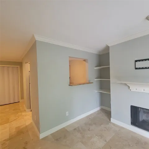 a view of empty room with cabinet and window