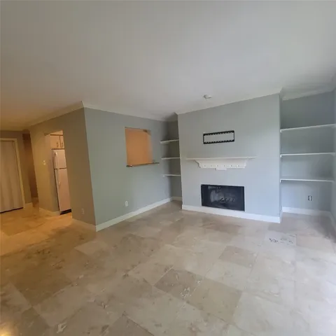 a view of an empty room with a fireplace and a window
