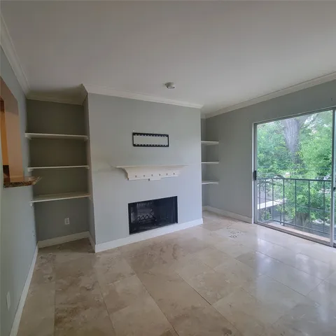 a view of an empty room with a fireplace and a window