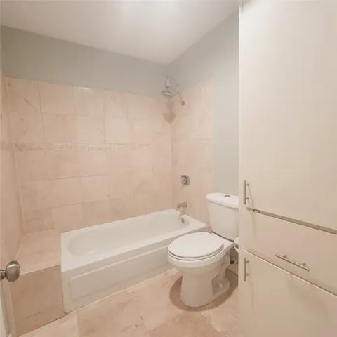 a white toilet and tub sitting next to a bathroom sink