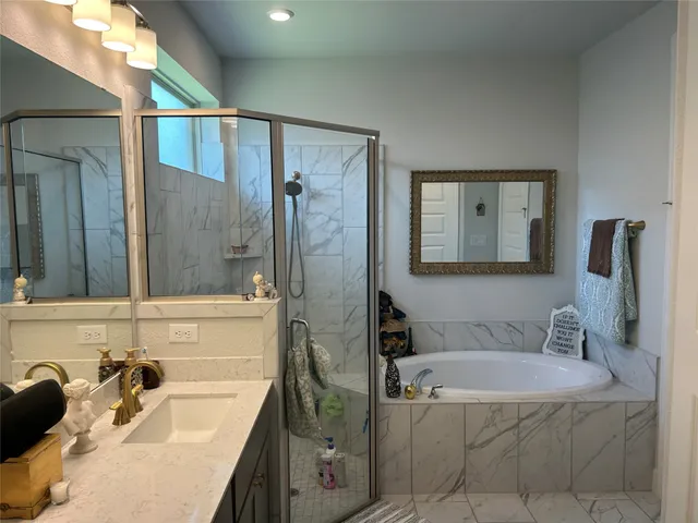 a bathroom with a tub a sink and a mirror