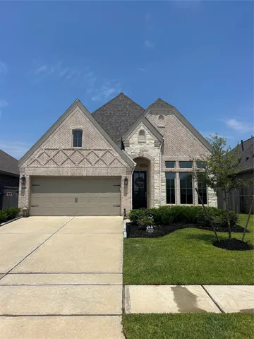 a front view of a house with a garden and plants