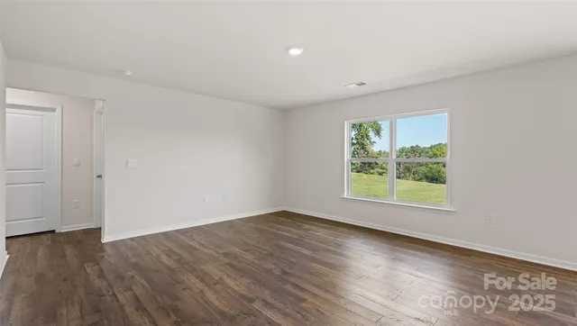 an empty room with wooden floor and window