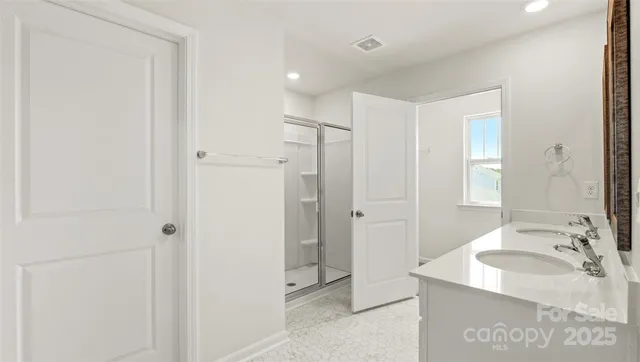 a bathroom with a granite countertop sink a mirror and a shower