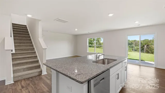 a kitchen with granite countertop a sink and a window