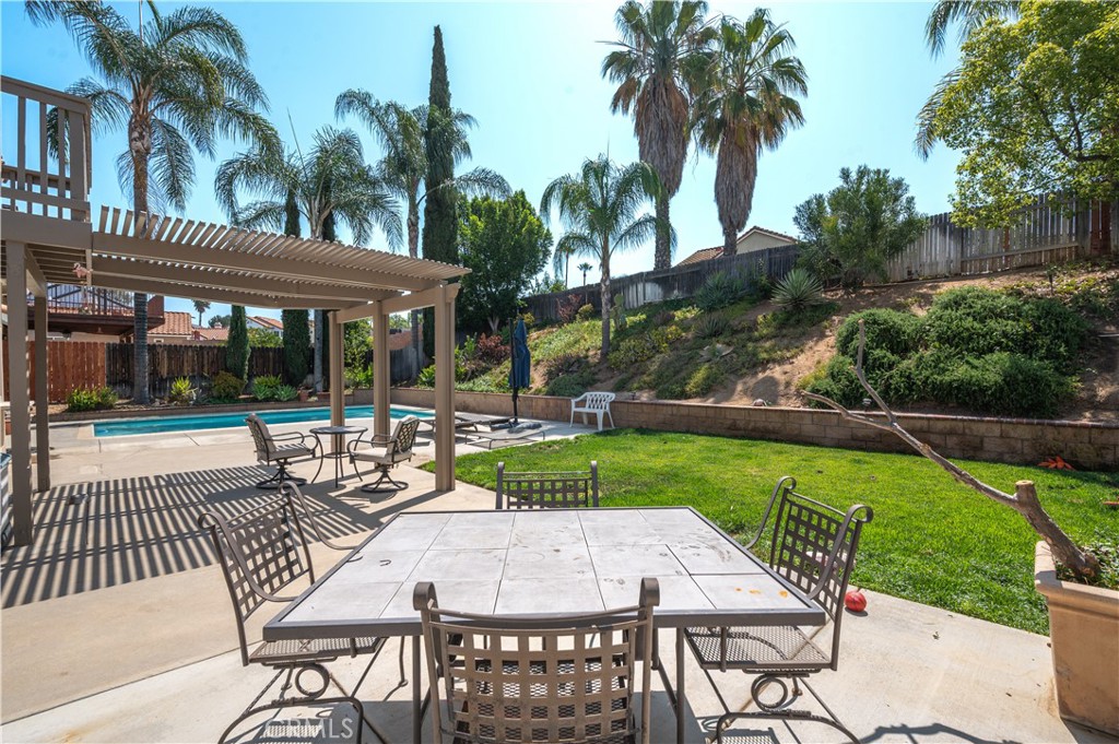 19465 Kinnow Lane Riverside, CA 92508 - Photo 45 of 61 a view of a patio with table and chairs potted plants and palm tree