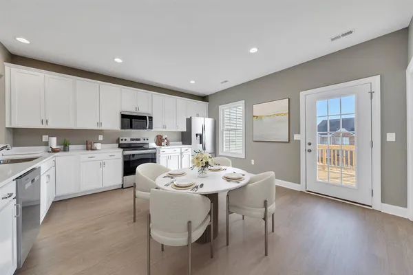 a kitchen with a sink white cabinets and a stove