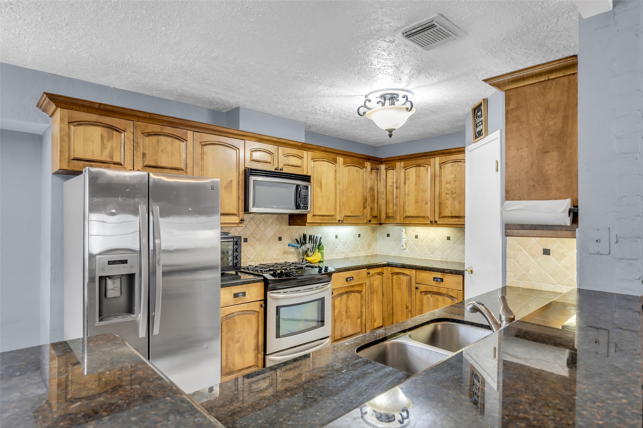21807 Meadowhill Drive Spring, TX 77388 - Photo 12 of 25 a kitchen with stainless steel appliances granite countertop a sink stove and refrigerator