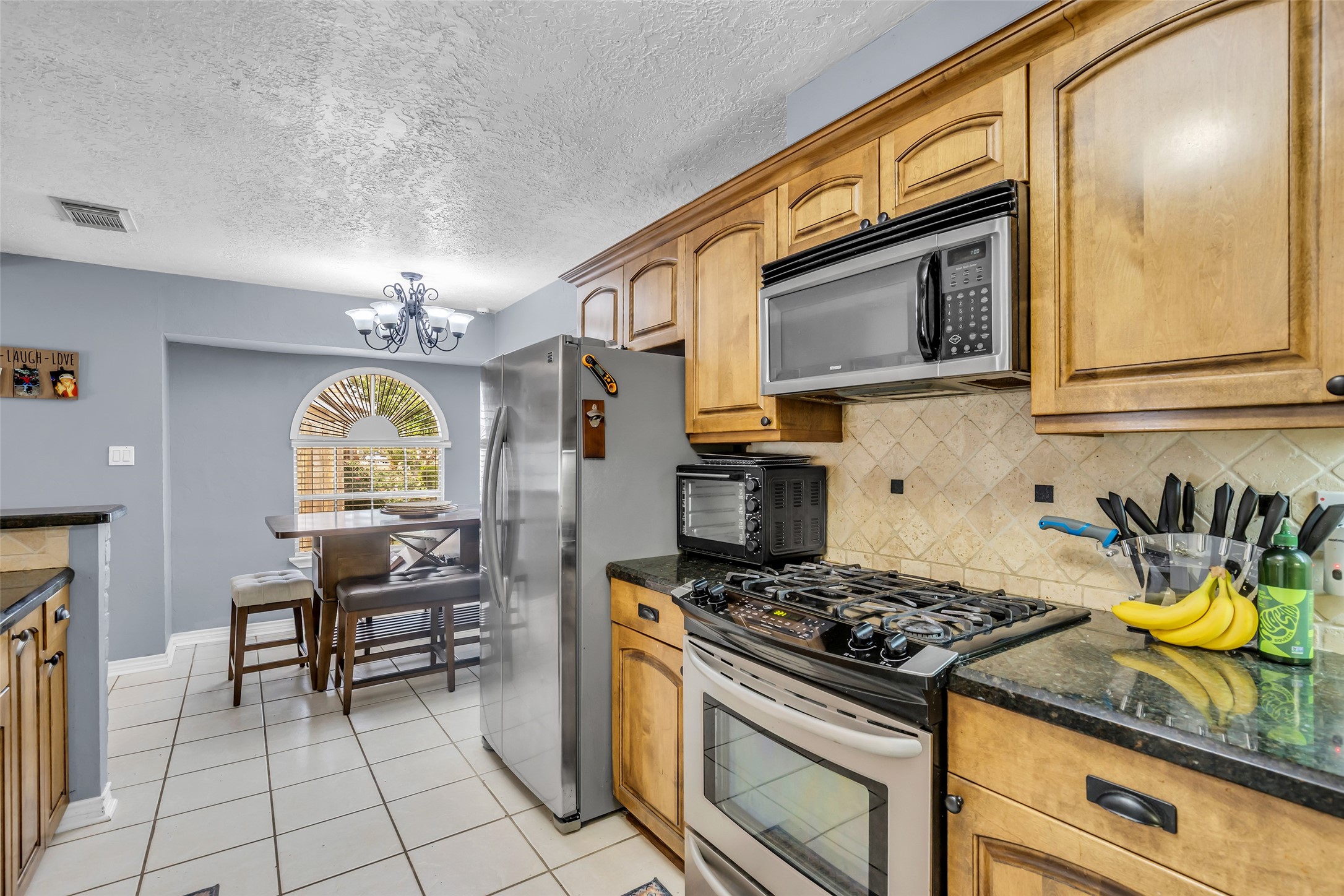 21807 Meadowhill Drive Spring, TX 77388 - Photo 16 of 25 a kitchen with stainless steel appliances granite countertop a stove a sink and a microwave
