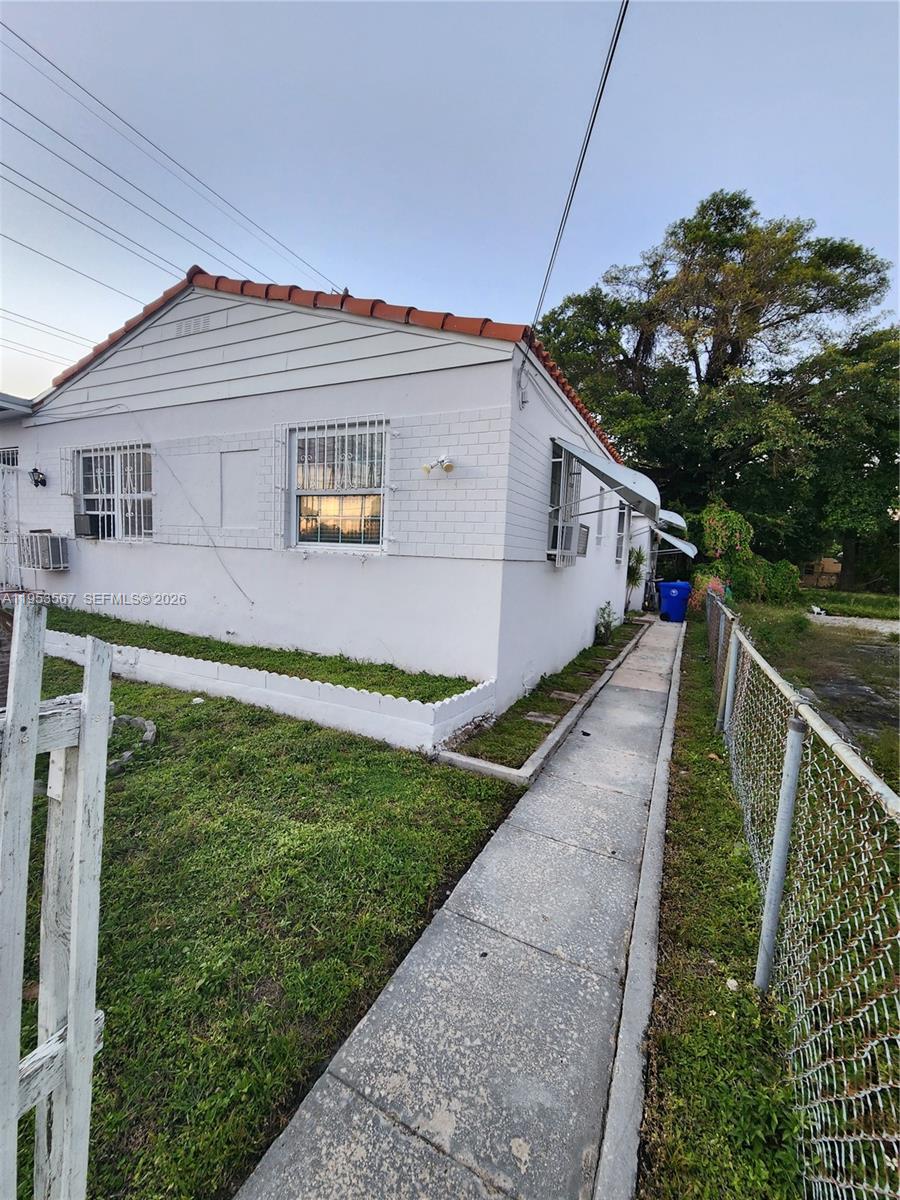 405 Northwest 64th Street, Unit 2 Miami, FL 33150 - Photo 2 of 13 a view of a house with a small yard and a garden