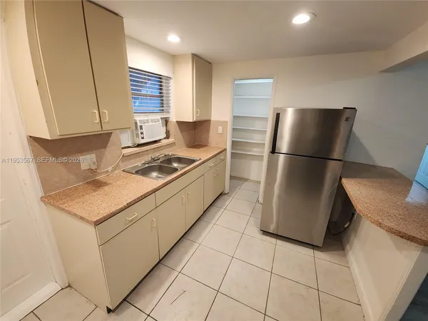 a kitchen with stainless steel appliances granite countertop a refrigerator sink and stove