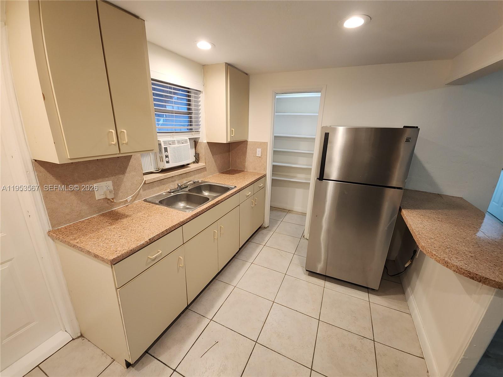 405 Northwest 64th Street, Unit 2 Miami, FL 33150 - Photo 5 of 13 a kitchen with stainless steel appliances granite countertop a refrigerator sink and stove