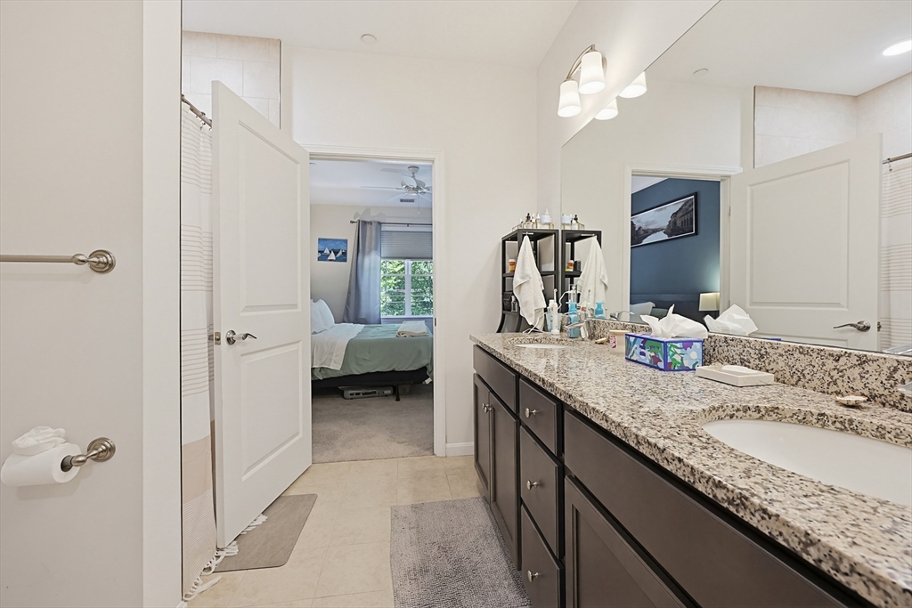 200 Revere Street, Unit 4209 Canton, MA 02021 - Photo 22 of 35 a en suite bathroom with a granite countertop sink and a mirror