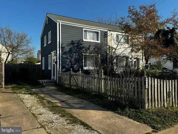 a view of a house with a small yard and wooden fence