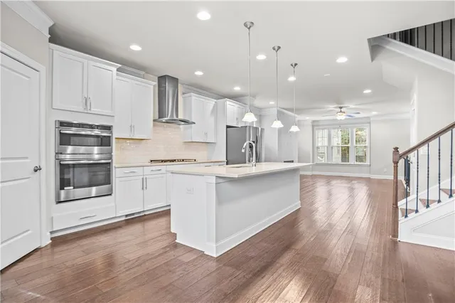 a large white kitchen with stainless steel appliances