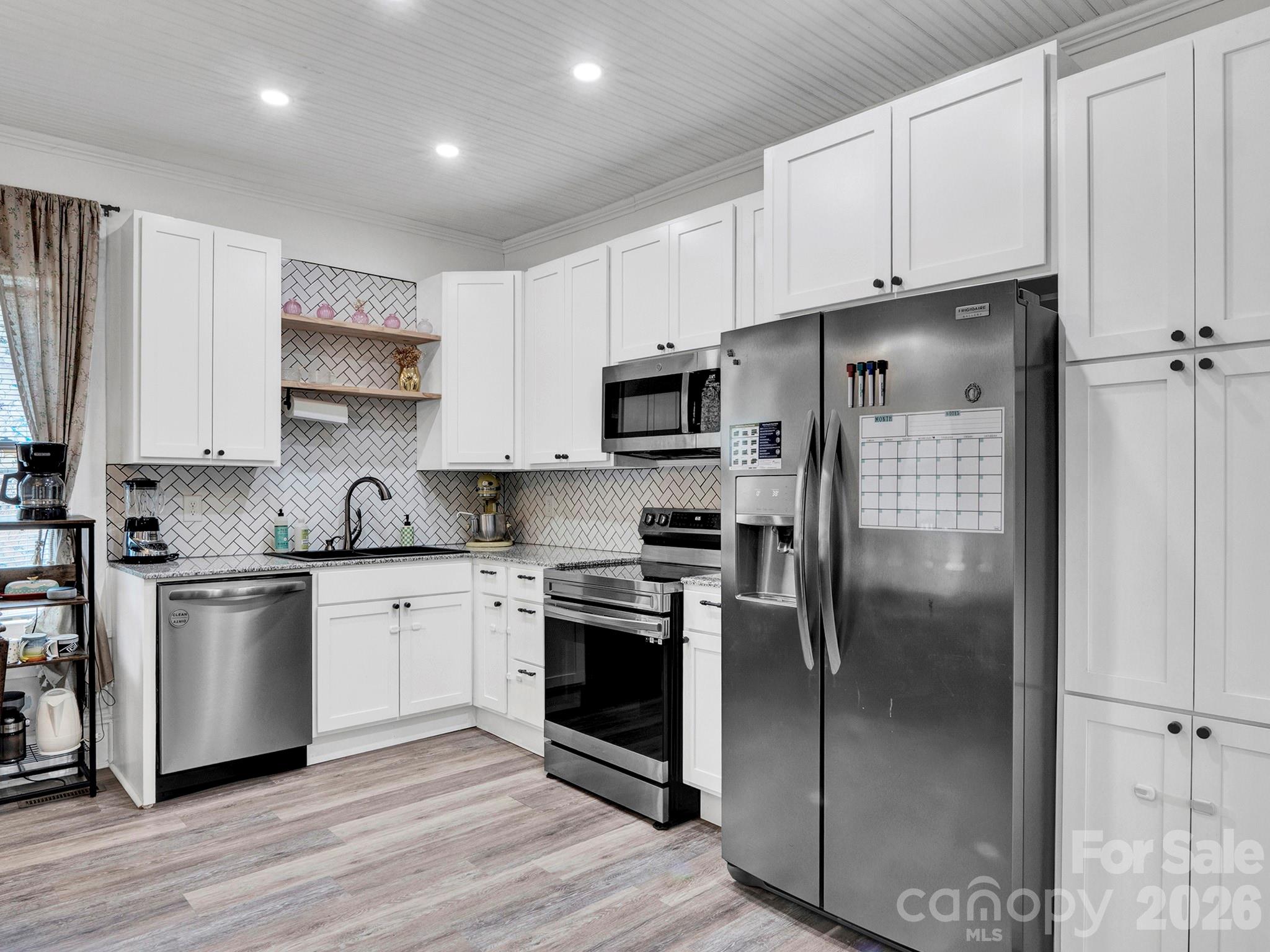 208 Hough Street Monroe, NC 28112 - Photo 11 of 32 a kitchen with stainless steel appliances granite countertop a refrigerator a stove and white cabinets