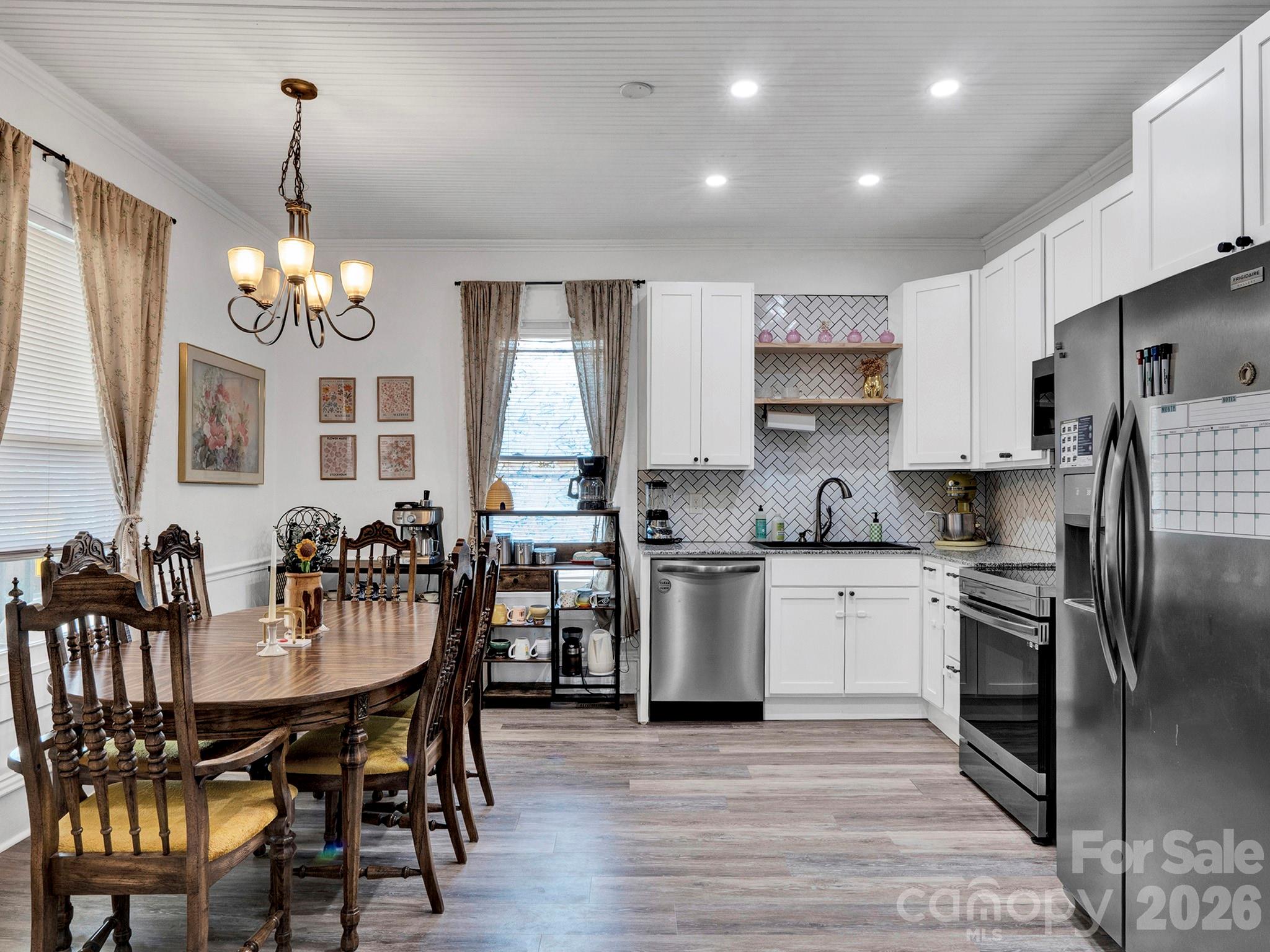 208 Hough Street Monroe, NC 28112 - Photo 13 of 32 a kitchen with stainless steel appliances kitchen island granite countertop a dining table chairs and granite counter tops