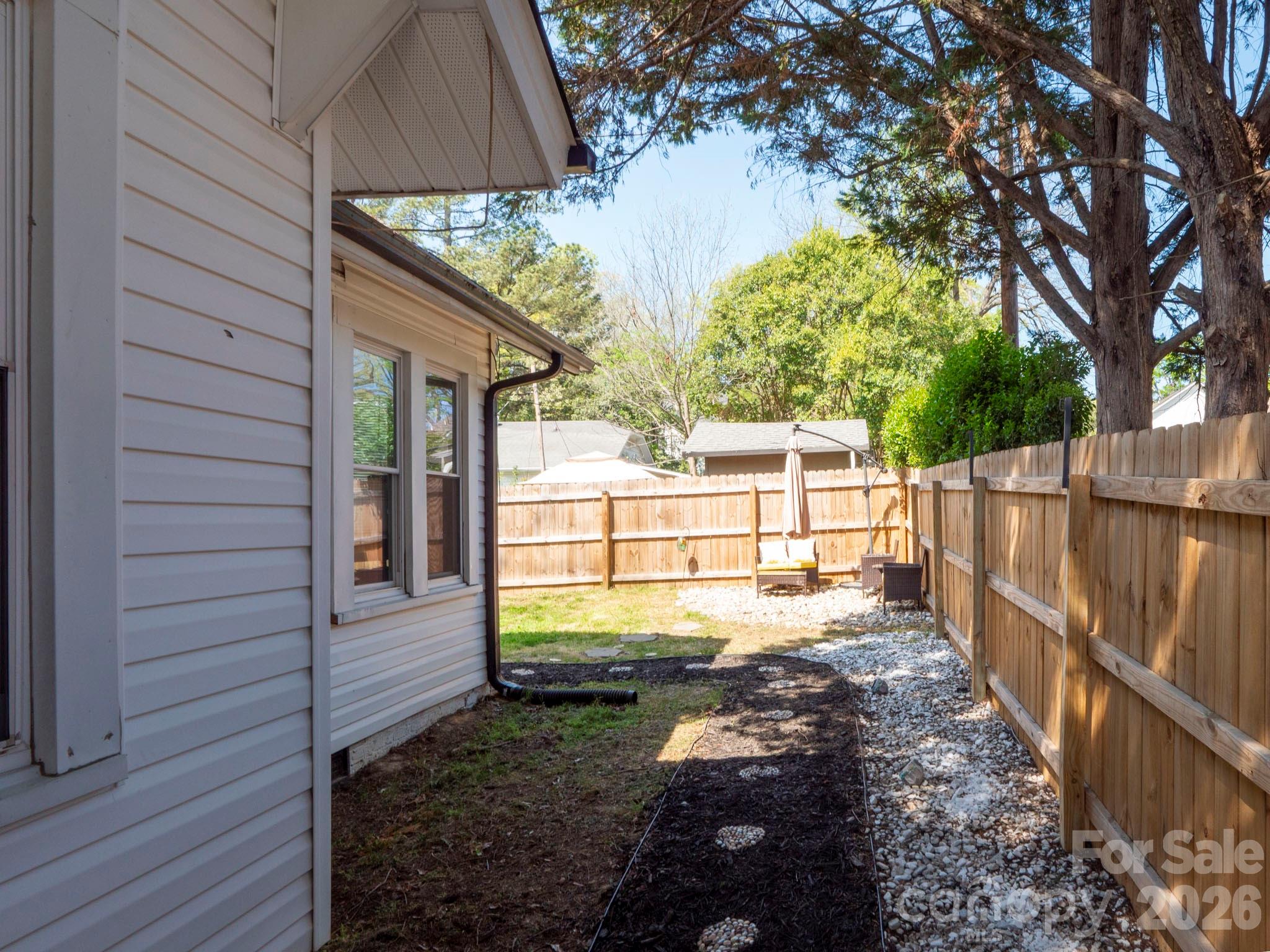 208 Hough Street Monroe, NC 28112 - Photo 28 of 32 a view of a backyard with wooden fence and large trees