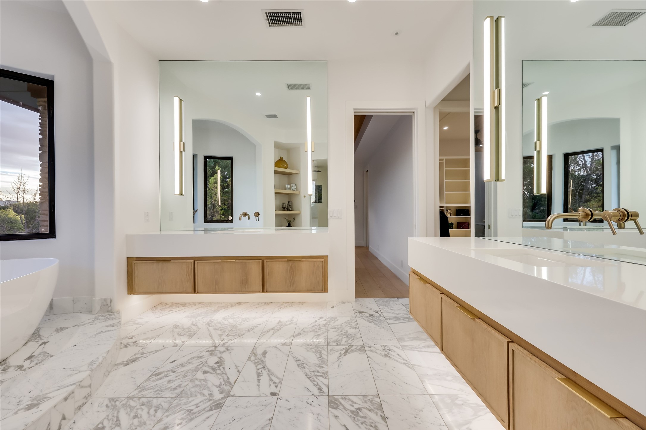 1016 Wild Basin Ledge Austin, TX 78746 - Photo 13 of 38 Primary bathroom featuring gold calcutta marble floors, a steam shower, a soaking tub, and vanities