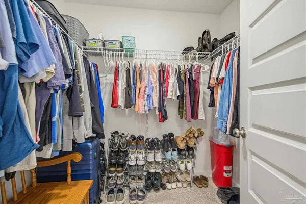 a view of walk in closet with clothes