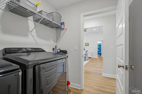 a view of a hallway with wooden floor and a bathroom