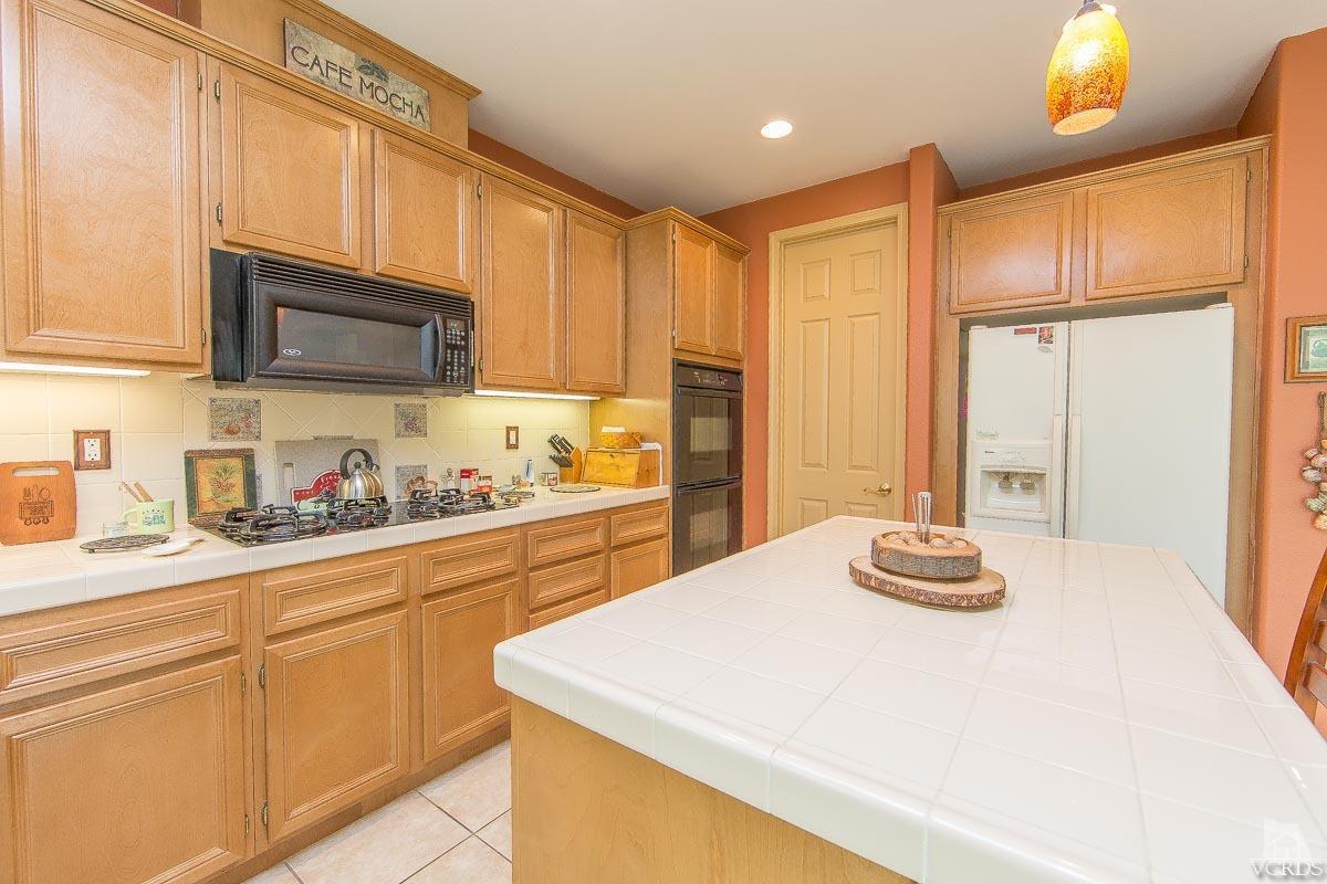 1487 Hidden Ranch Drive Simi Valley, CA 93063 - Photo 14 of 28 a kitchen with stainless steel appliances granite countertop a sink refrigerator and cabinets