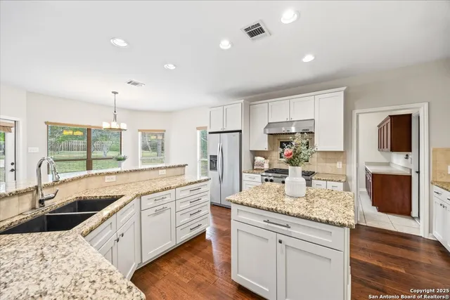 a kitchen with stainless steel appliances granite countertop a stove and a sink