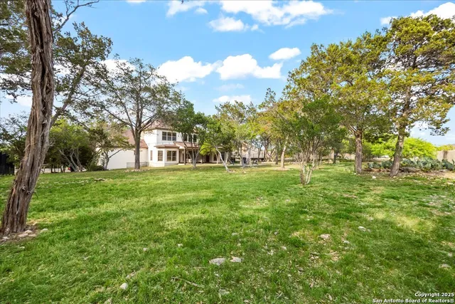 an aerial view of residential houses with outdoor space and trees