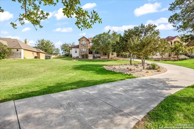 an aerial view of residential houses with outdoor space and trees