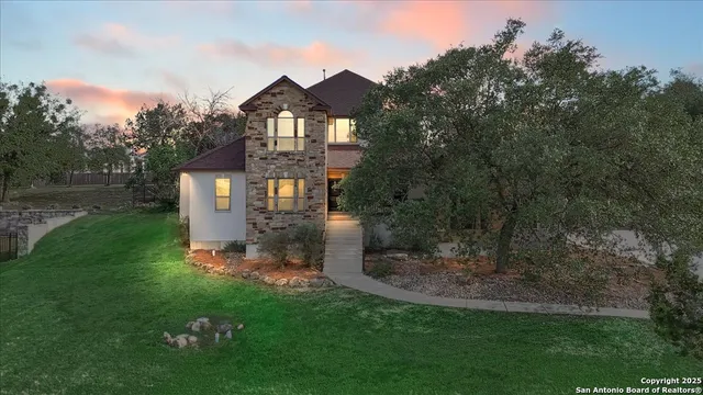 a view of a big house with a big yard and large trees