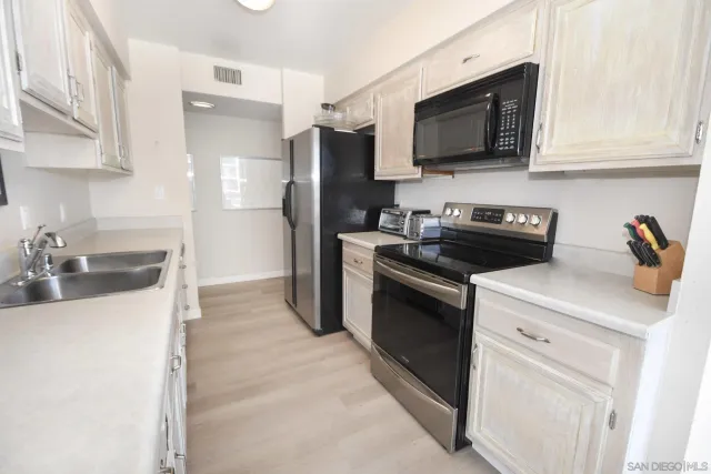 a kitchen with stainless steel appliances granite countertop a sink stove and microwave