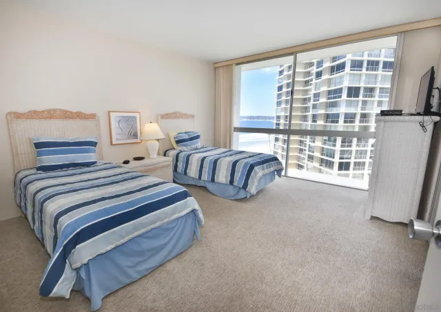 a spacious bedroom with two beds and a large window