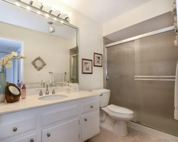 a bathroom with a double vanity sink mirror and toilet