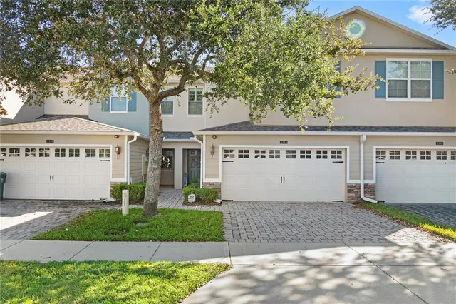 a view of a white house with large windows and a small yard