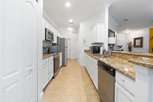 a kitchen with stainless steel appliances granite countertop a refrigerator a stove top oven a sink and dishwasher