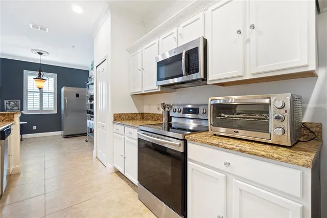 a kitchen with granite countertop white cabinets stainless steel appliances and sink