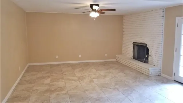 en empty room with ceiling fan and window