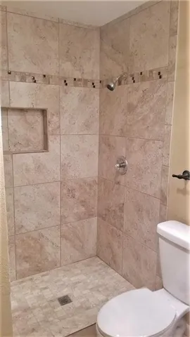 a bathroom with a toilet and a shower