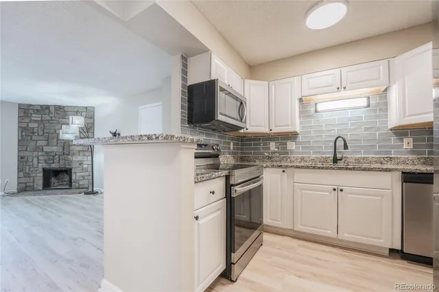 a kitchen with stainless steel appliances granite countertop a stove sink and cabinets