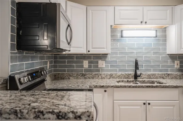 a kitchen with granite countertop a sink and cabinets