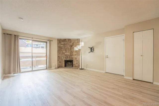 wooden floor fireplace and windows in an empty room