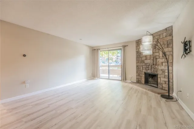 wooden floor fireplace and windows in an empty room
