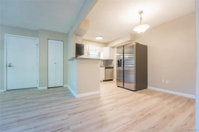 a view of a kitchen with refrigerator and a stove