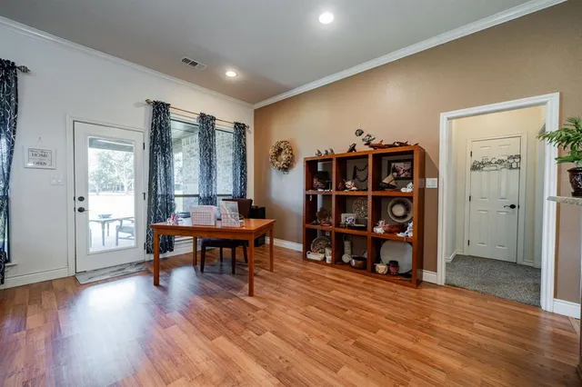 a living room with furniture a lamp and wooden floor