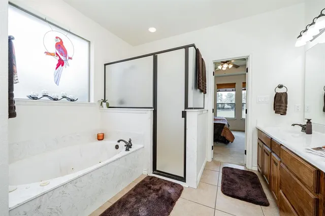 a bathroom with a tub a sink and glass door