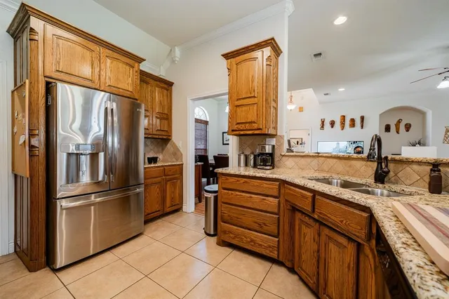 a kitchen with stainless steel appliances granite countertop a refrigerator and a stove top oven
