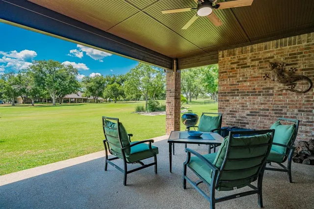 a view of chairs and table in patio with a yard
