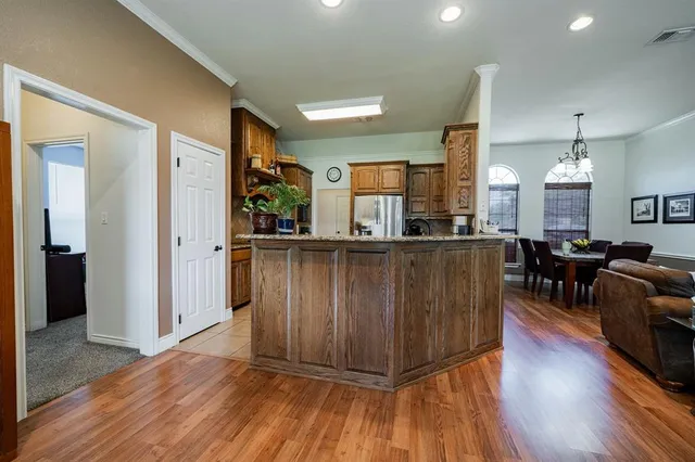 a kitchen with stainless steel appliances kitchen island granite countertop wooden floors and view living room